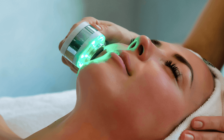 doctor using led light therapy to a womans face