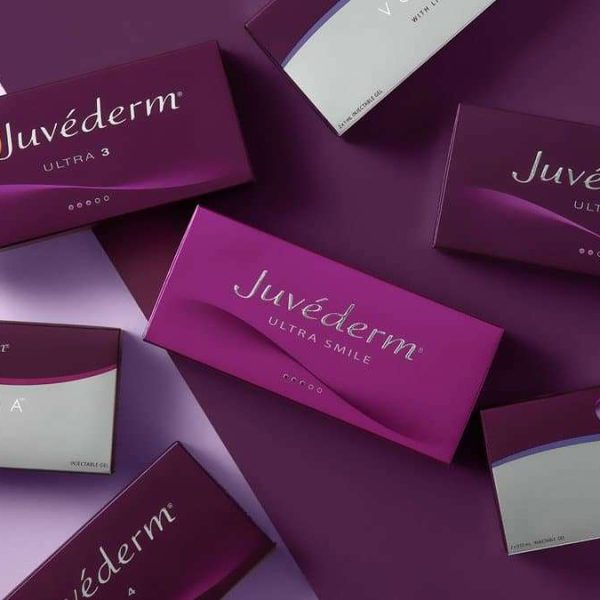 several boxes of juvederm products on a purple surface