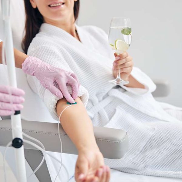 smiling female patient undergoing intravenous vitamin therapy